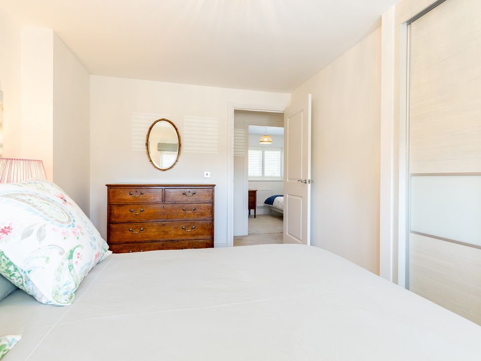 A bedroom with a bed and dresser in view at Old Railway Close Lechlade-On-Thames