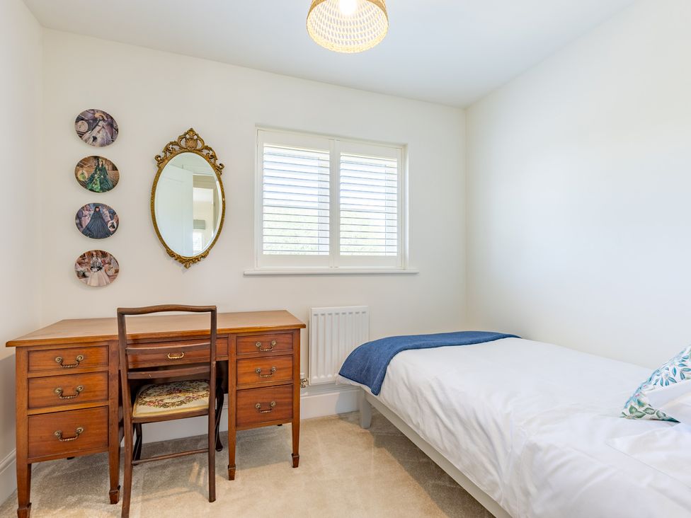 A bedroom with a bed and a desk at Old Railway Close, Lechlade-On-Thames
