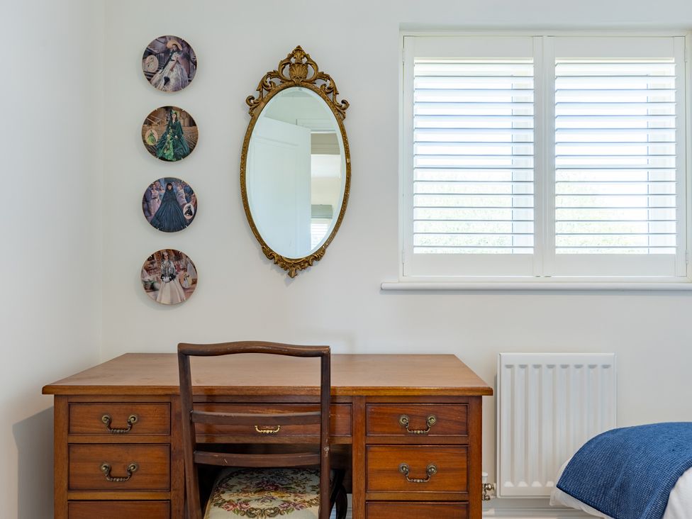 A bedroom with a desk and mirror at Old Railway Close in Lechlade-On-Thames