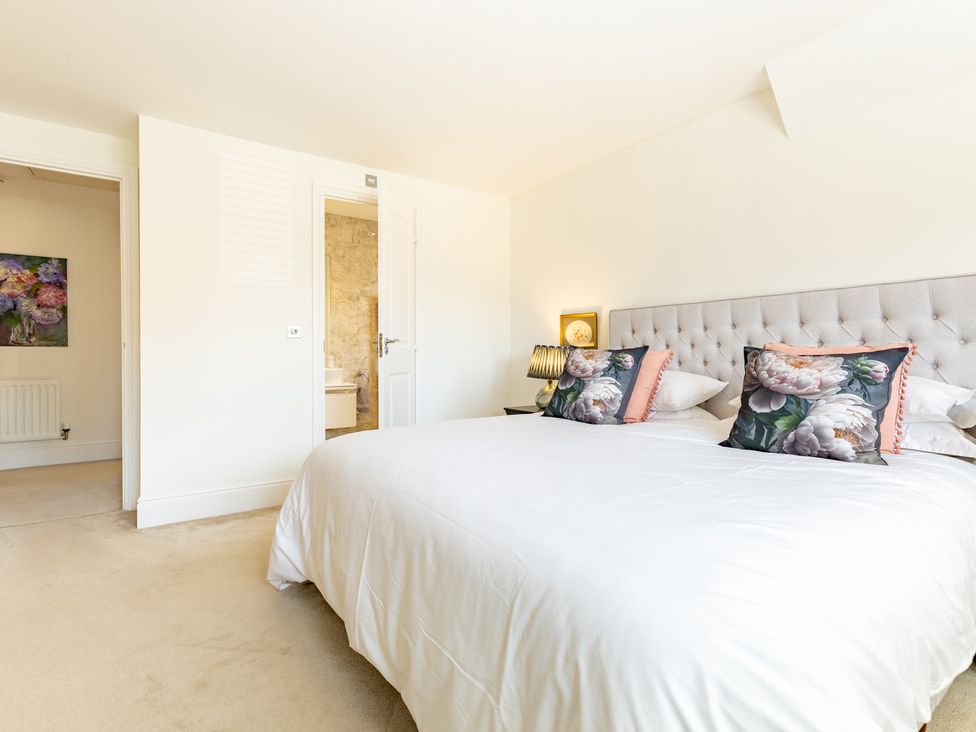 A bedroom with a bed and wall art at Old Railway Close in Lechlade-On-Thames