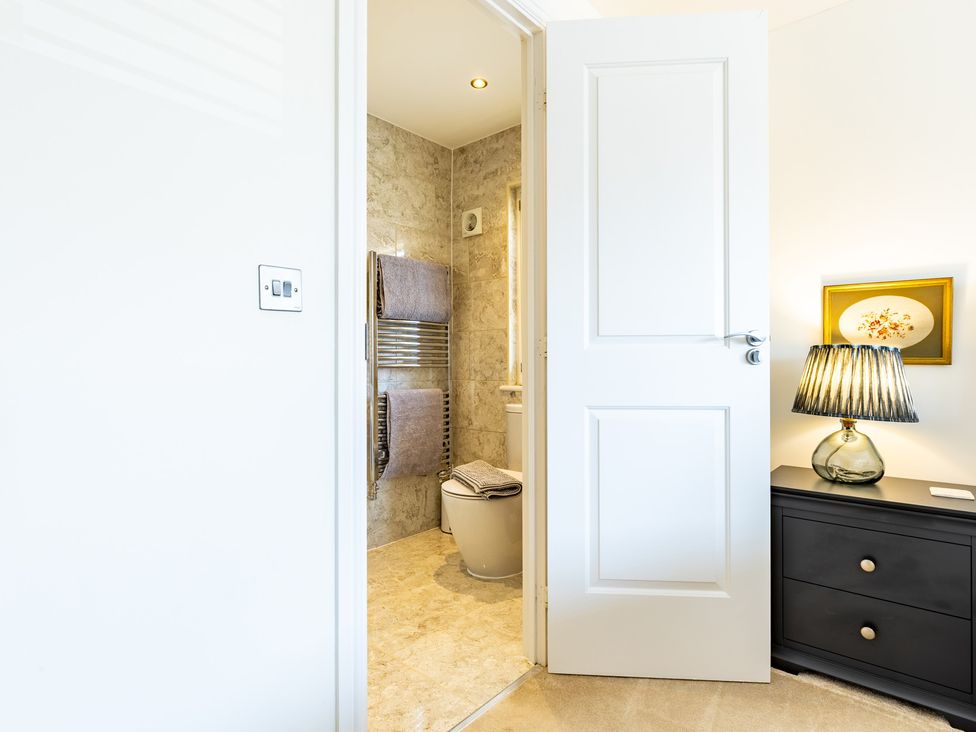 A bathroom with a toilet, towel rail, and a lamp at Old Railway Close in Lechlade-On-Thames