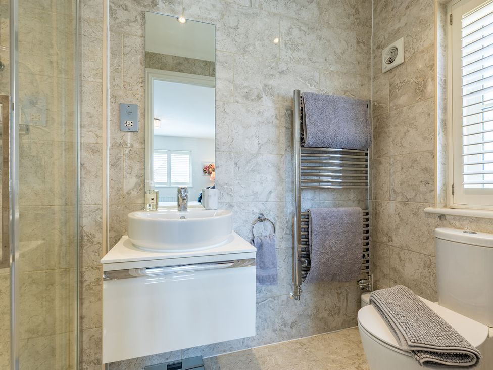 A bathroom with sink, mirror, shower and towel rack at Old Railway Close Lechlade-On-Thames