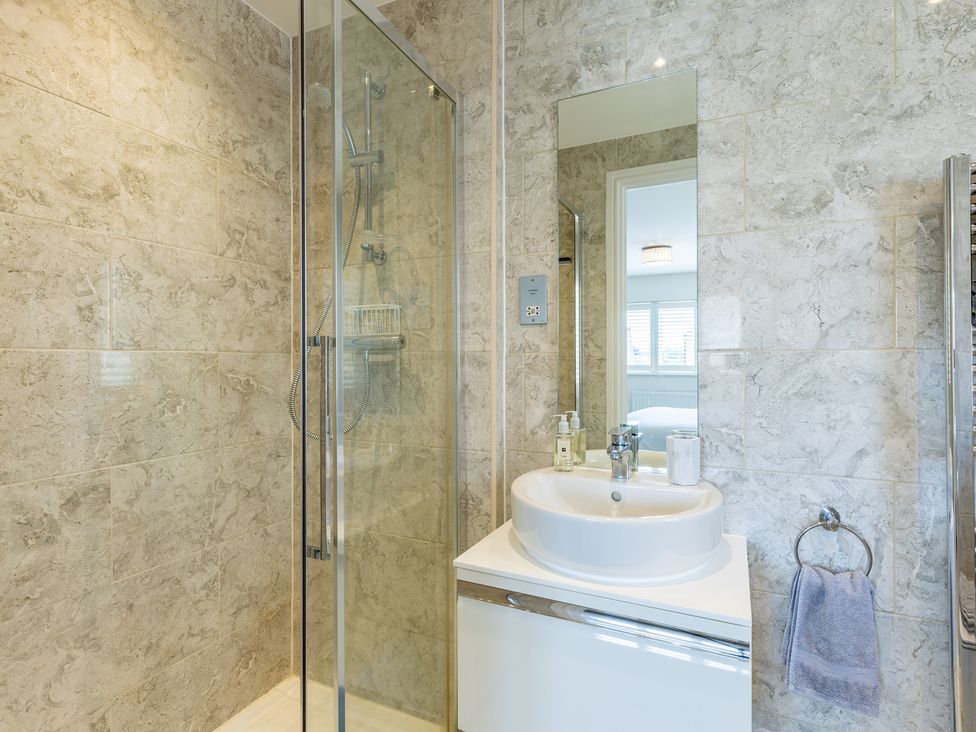 A bathroom with a shower, sink, and mirror at Old Railway Close Lechlade-On-Thames