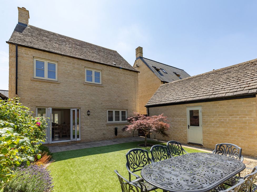 A garden with a table and chairs at Old Railway Close Lechlade-On-Thames