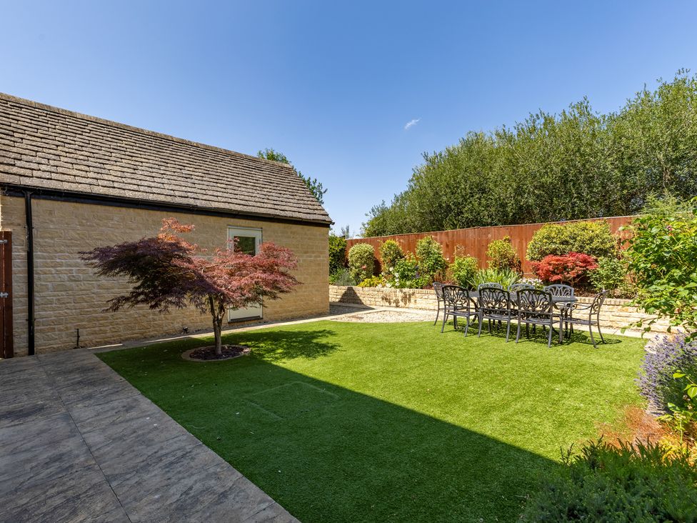 A garden with a table and chairs at Old Railway Close Lechlade-On-Thames