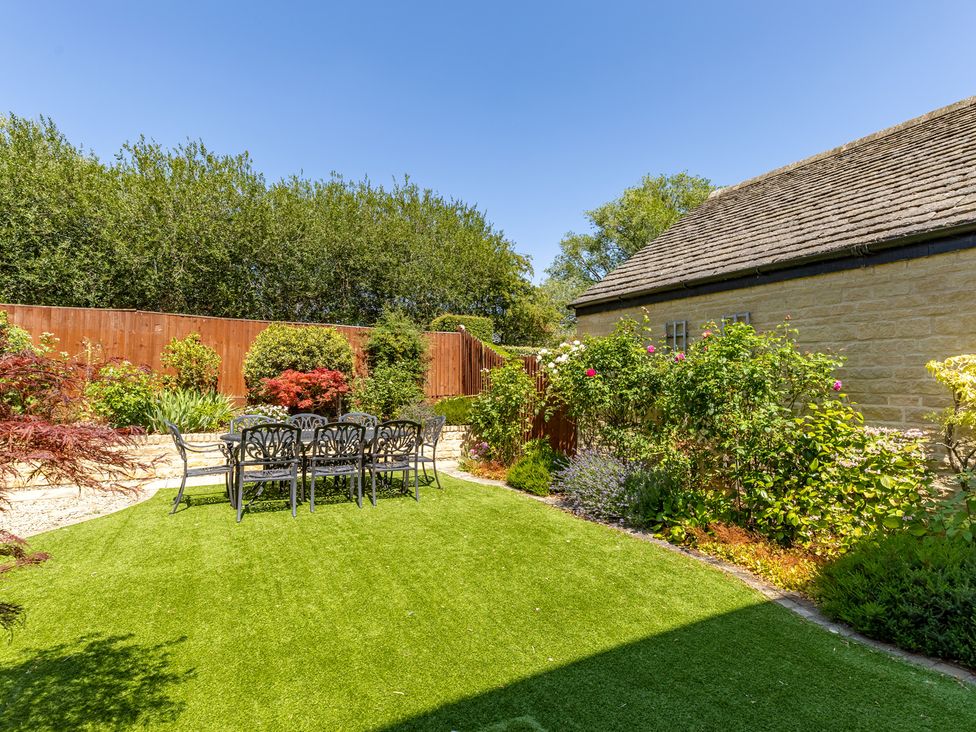 A garden with a table and chairs at Old Railway Close in Lechlade-On-Thames