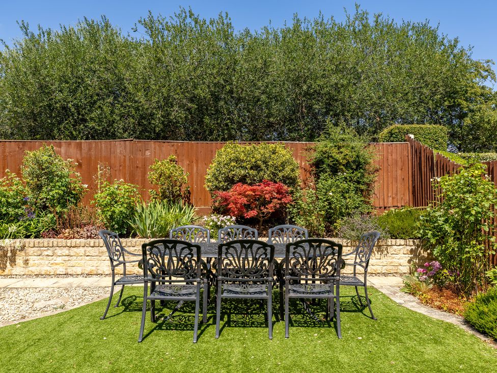 A garden with a table and chairs at Old Railway Close in Lechlade-On-Thames