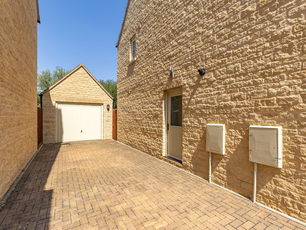 A driveway with a garage and utility boxes at Old Railway Close Lechlade-On-Thames