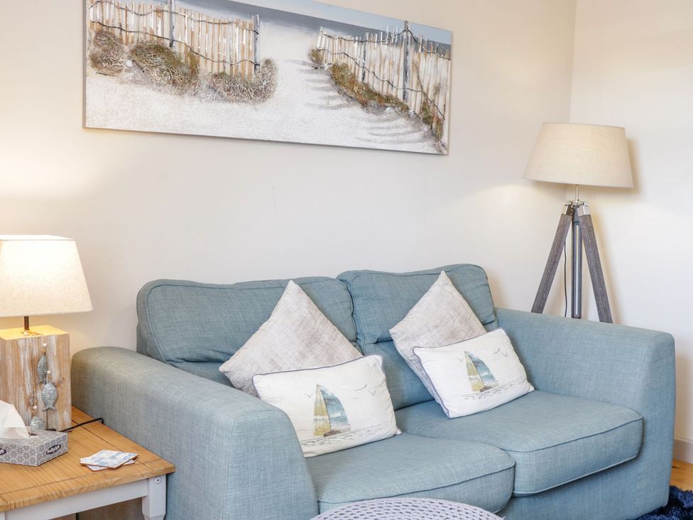 A living room with a sofa and lamp at Eryri View Retreat in 