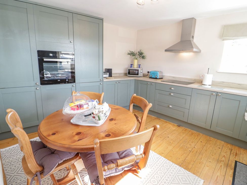 A kitchen with appliances and a dining table at Eryri View Retreat