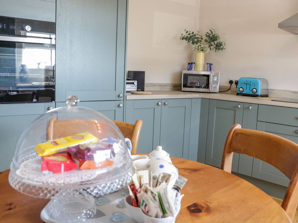 A kitchen with a table and cake stand at Eryri View Retreat