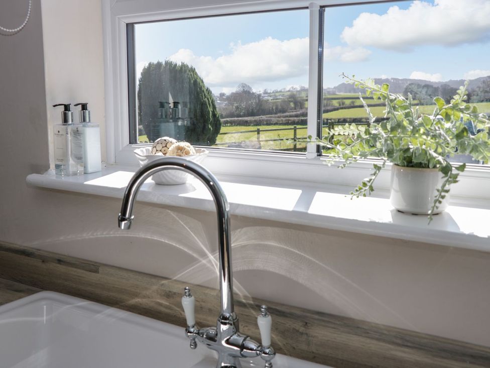 A sink with a faucet and window view at Eryri View Retreat