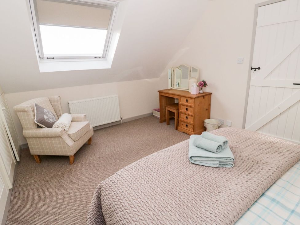 A bedroom with a bed and dressing table at Eryri View Retreat