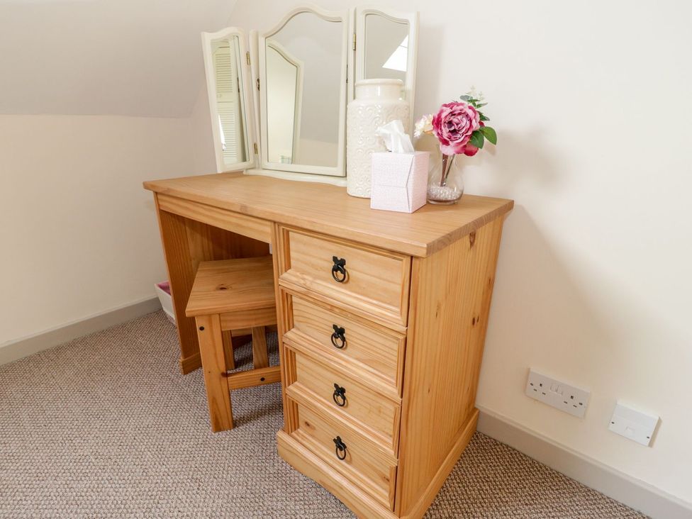 A bedroom with a vanity table and mirror at Eryri View Retreat