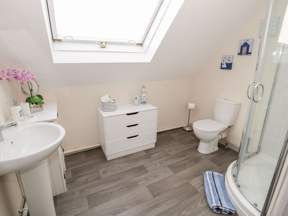 A bathroom with a shower and wash basin at Eryri View Retreat