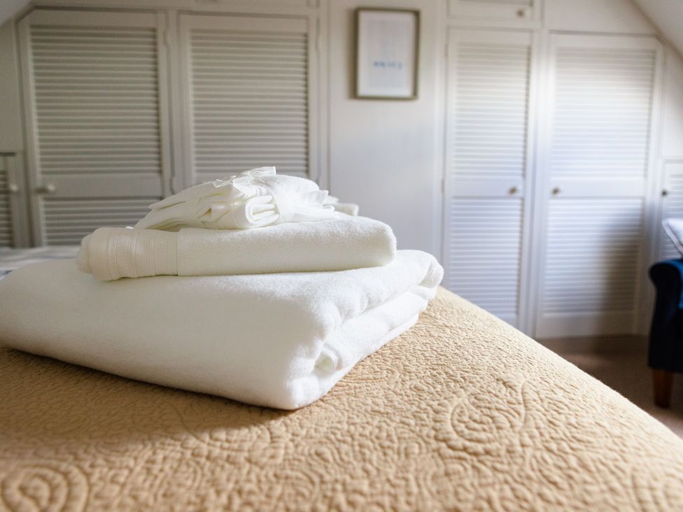 A stack of towels on a bed in Eryri View Retreat Llangoed near Beaumaris