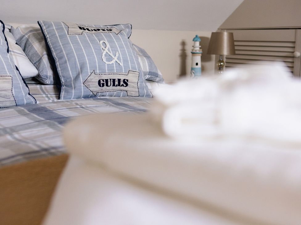 A bedroom with striped pillows and a decorative lamp at Eryri View Retreat Llangoed near Beaumaris