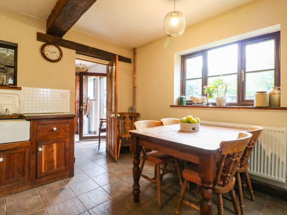A kitchen with a wooden table and chairs at The Barn in Tamworth