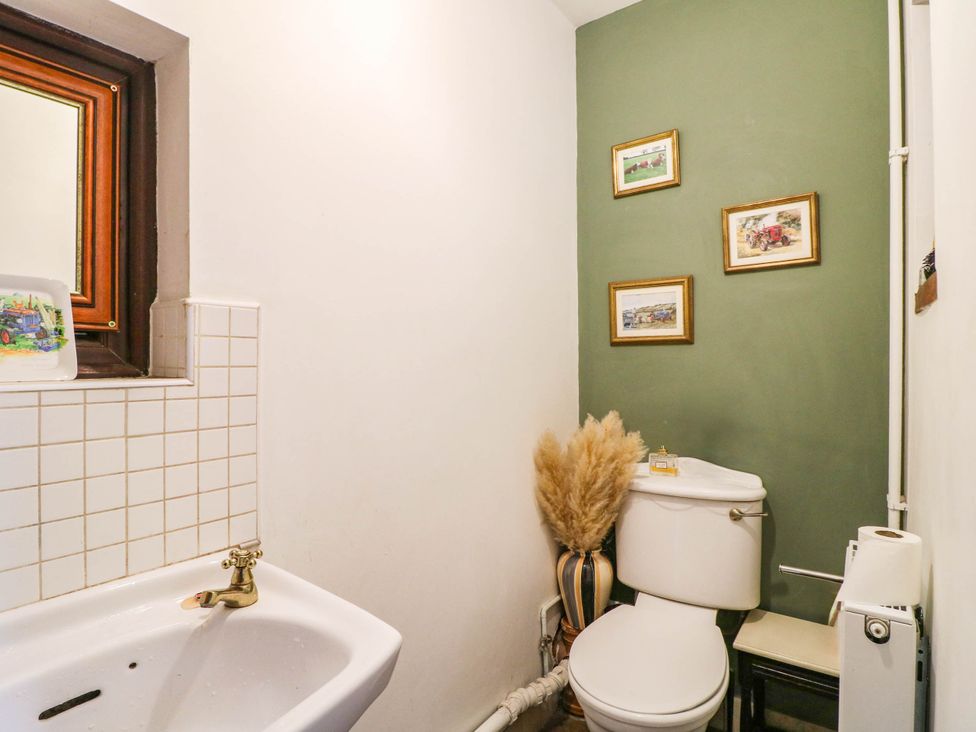 A bathroom with a toilet, sink, and window at The Barn in Tamworth