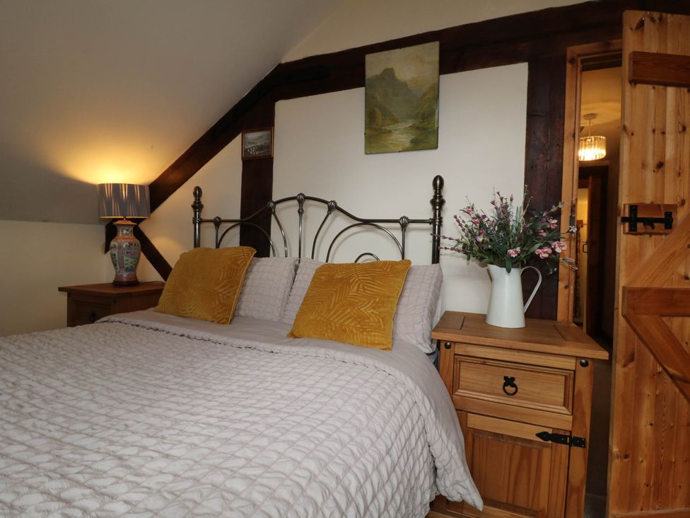 A bedroom with a bed and nightstand at The Barn in Tamworth