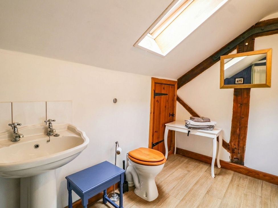 A bathroom with a sink, toilet, and a mirror at The Barn in Tamworth