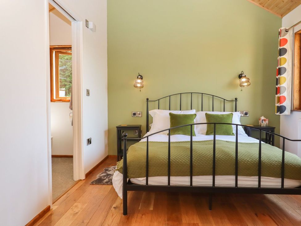 A bedroom with a bed and window at Nelli Lodge at Mile End, Crediton