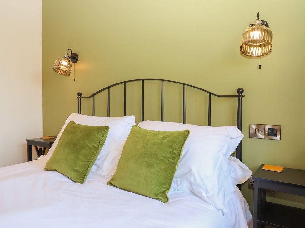 A bedroom with a bed and bedside table at Nelli Lodge at Mile End, Crediton