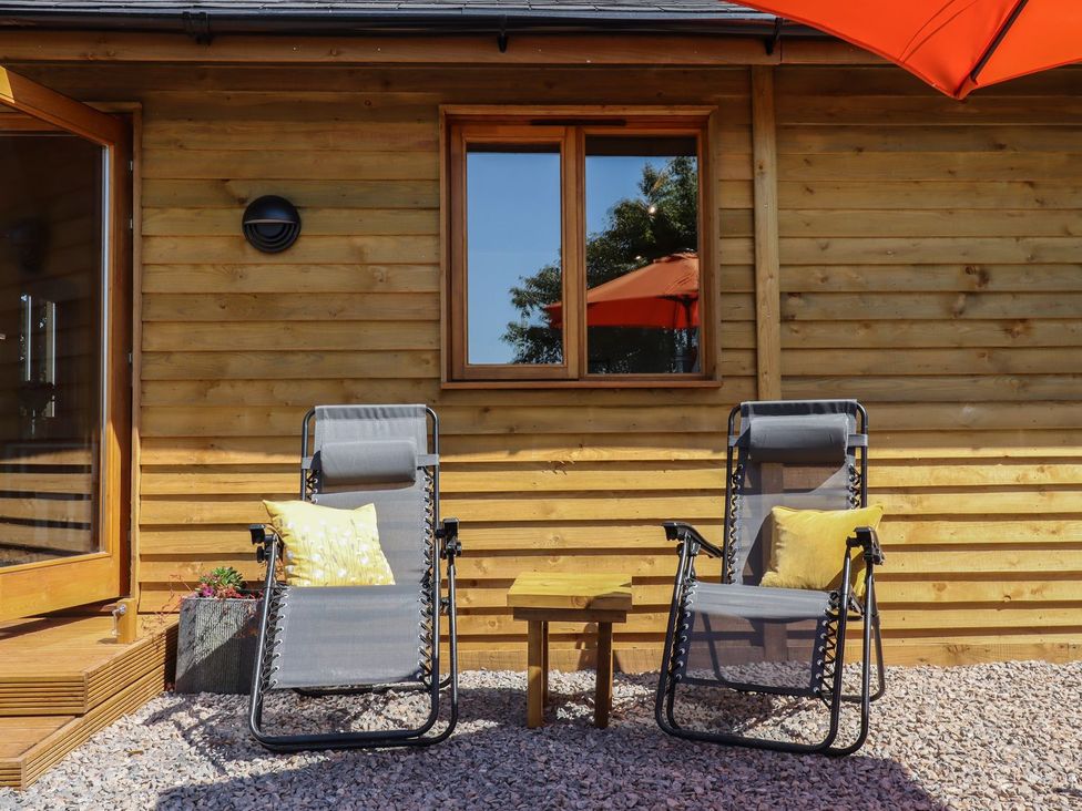 An outdoor seating area with chairs and a coffee table at Nelli Lodge at Mile End, Crediton