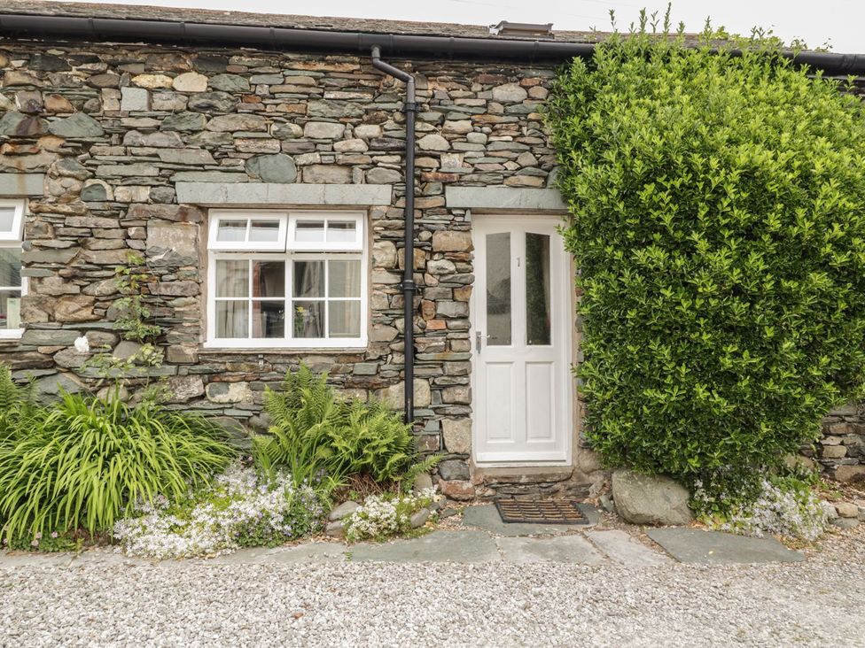 A stone wall with a door and window at Cottage 1 in Braithwaite