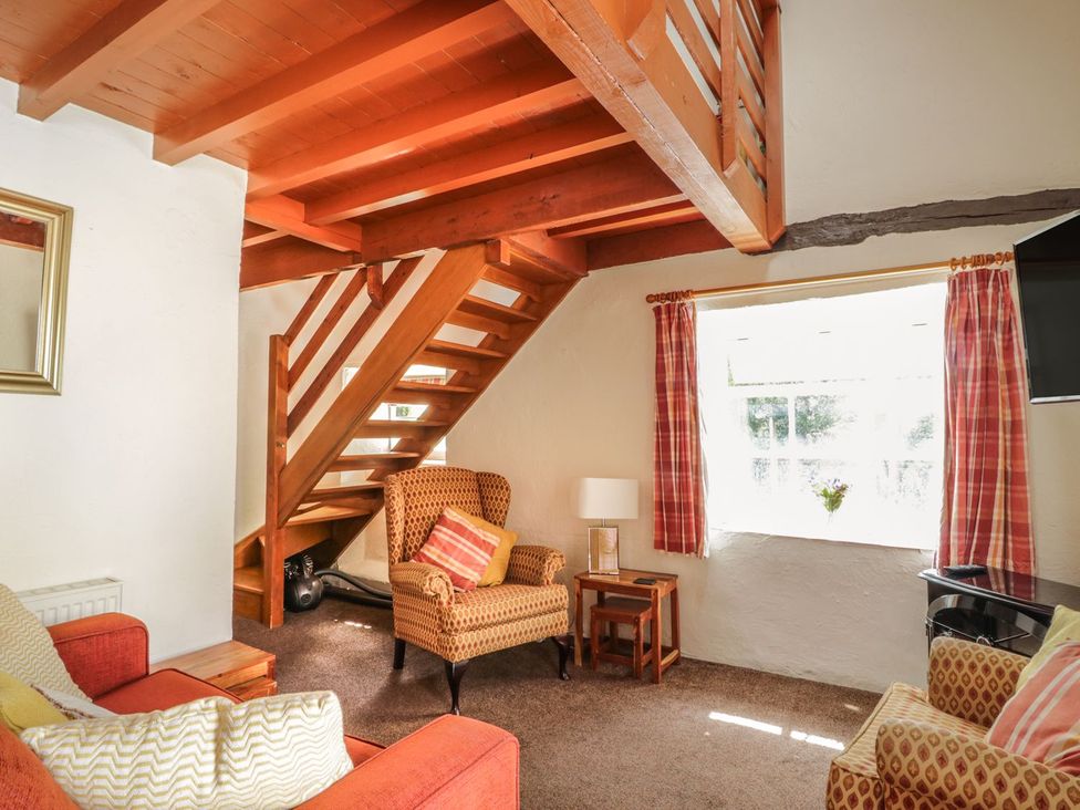 A living room with a staircase and a sofa at Cottage 1 in Braithwaite