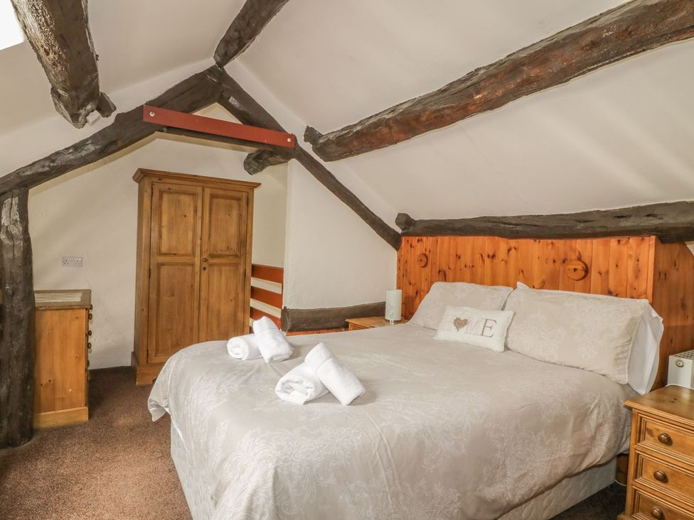 A bedroom with a bed and wardrobe at Cottage 1 in Braithwaite