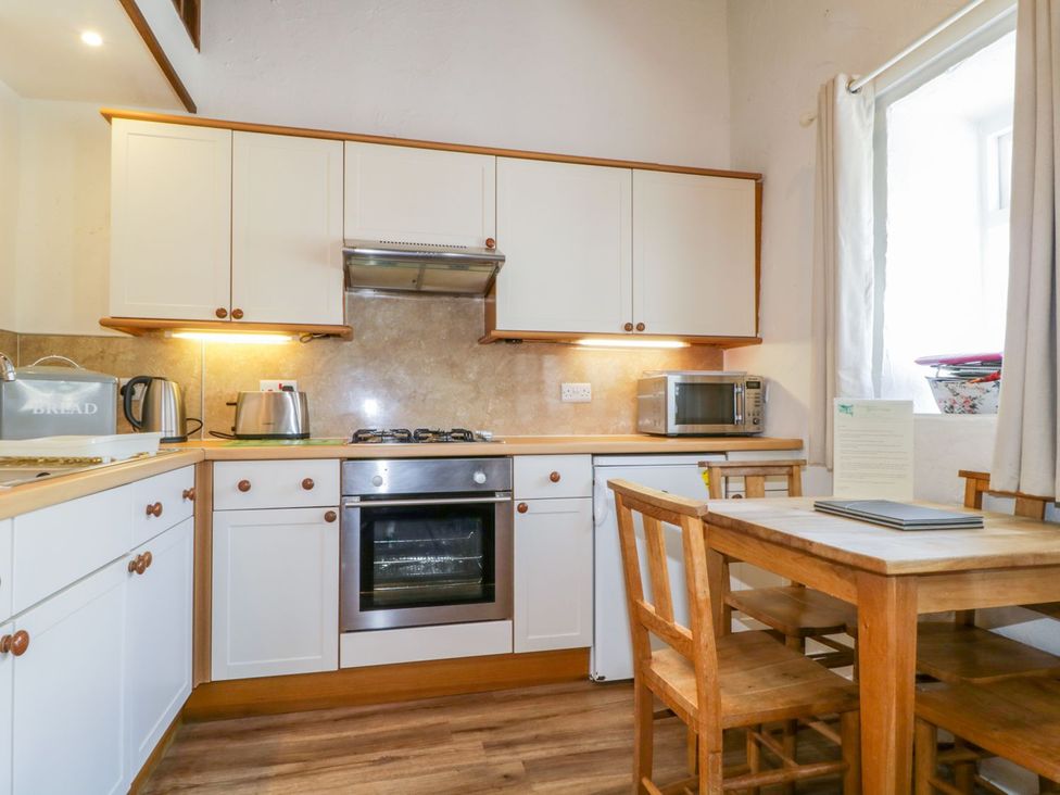 A kitchen with cabinets and appliances at Cottage 2 in Keswick