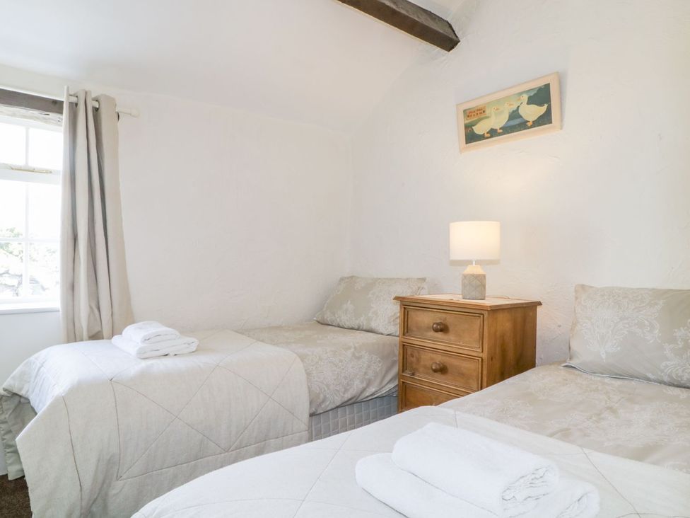 A bedroom with two beds and a lamp at Cottage 2 in Keswick