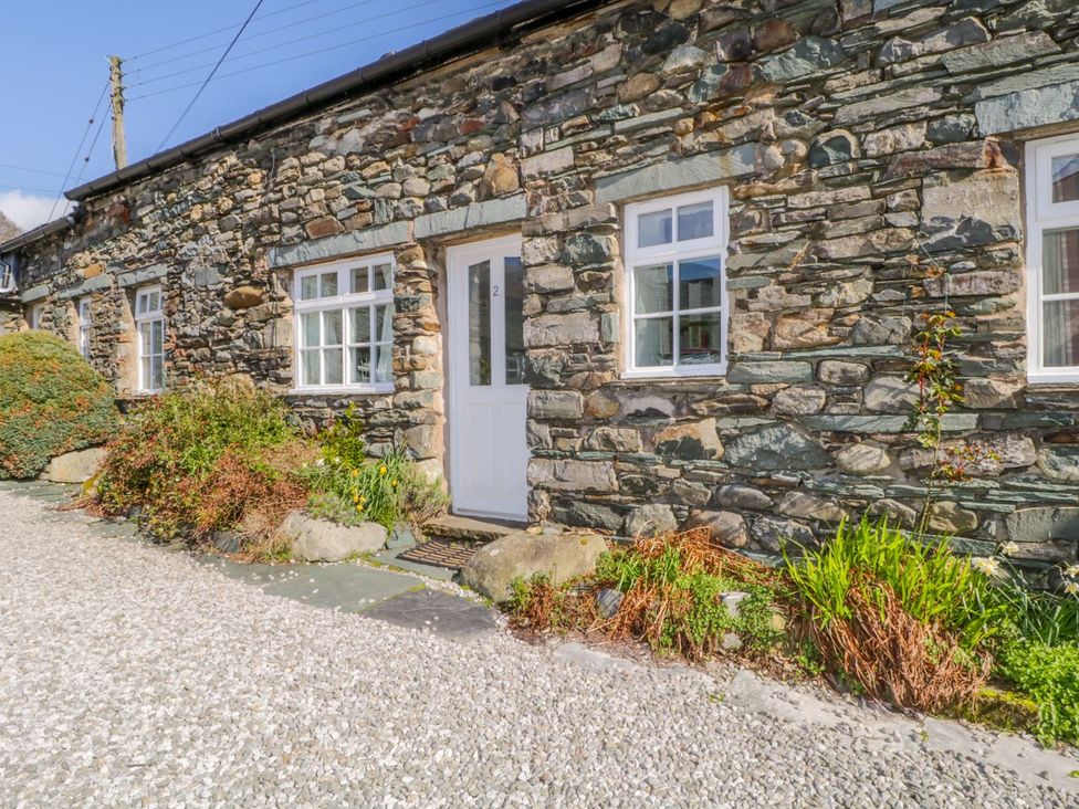 An exterior view of a stone cottage with greenery at Cottage 2 Keswick