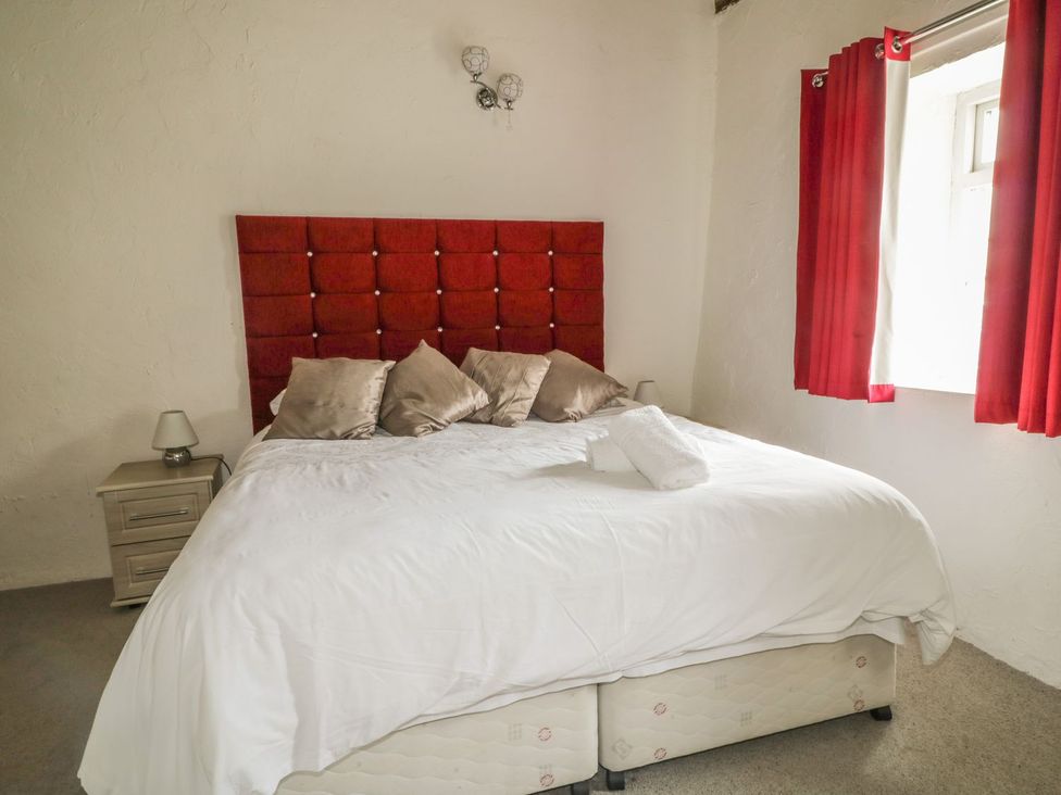 A bedroom with a bed and bedside table at Cottage 3 in Keswick