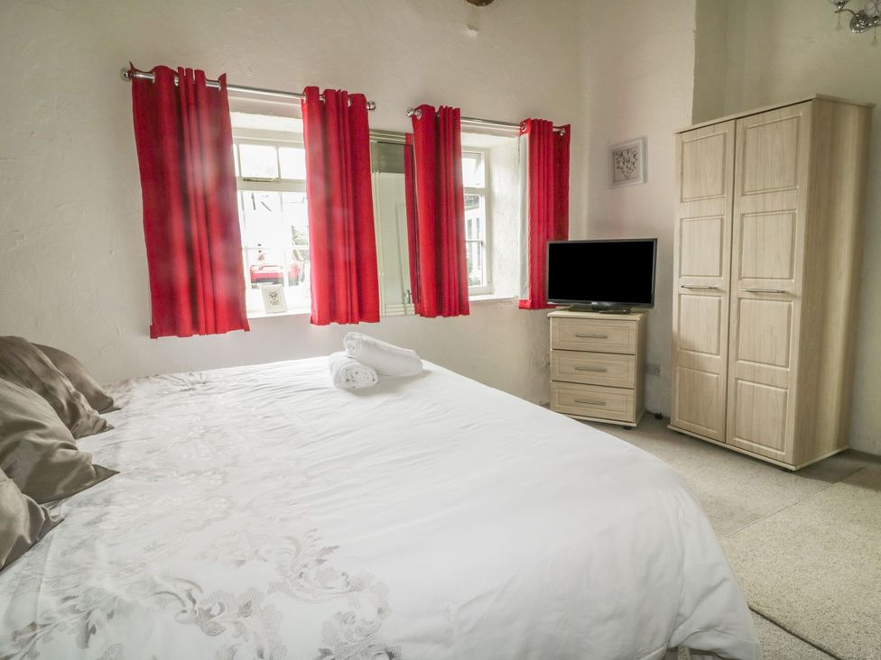 A bedroom with a bed and television at Cottage 3 in Keswick
