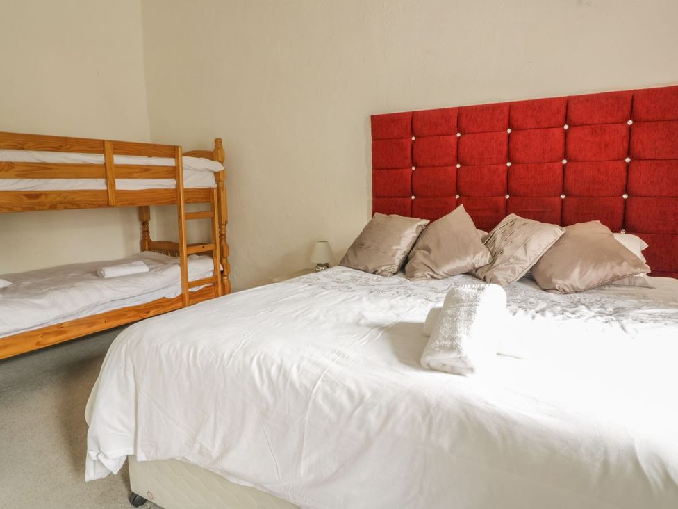 A bedroom with a double bed and a bunk bed at Cottage 3 in Keswick