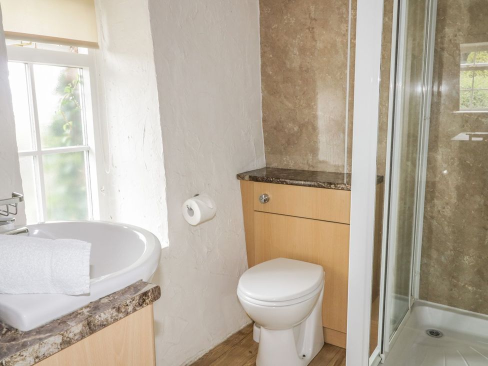 A bathroom with sink, toilet, and shower at Cottage 3 in Keswick