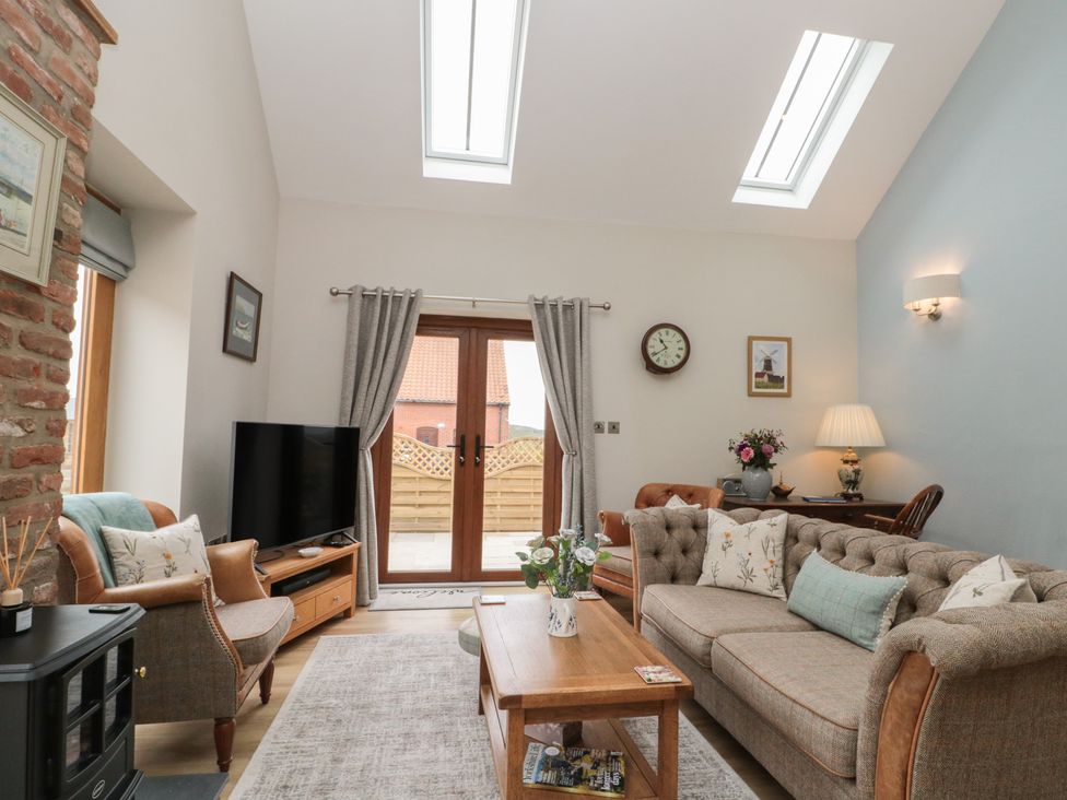 A living room with a television and curtains at Bumble Bee Lodge in Filey