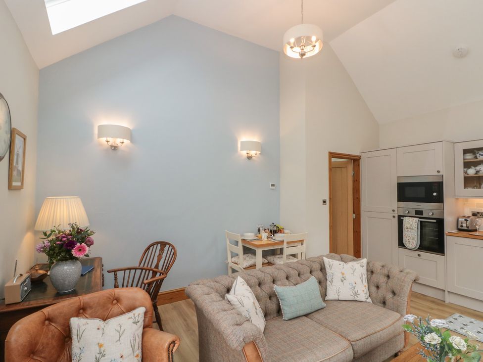 A living room with a sofa and table at Bumble Bee Lodge in Filey