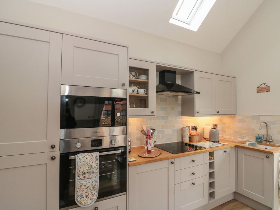 A kitchen with cabinets and appliances at Bumble Bee Lodge in Filey