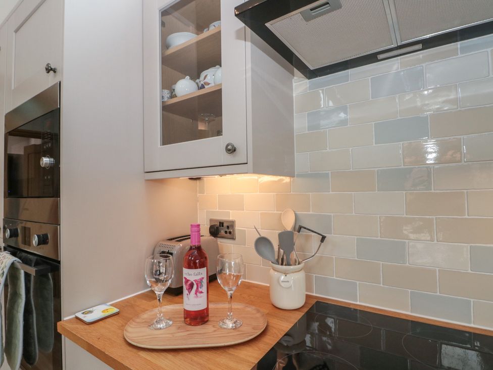A kitchen with cooking utensils and wine glasses at Bumble Bee Lodge in Filey