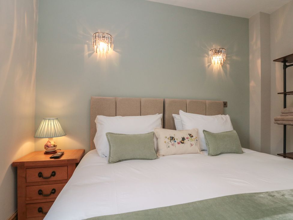 A bedroom with a bed and bedside table at Bumble Bee Lodge in Filey