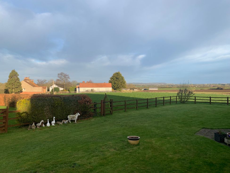 A garden with a fence and ducks at Bumble Bee Lodge in Muston