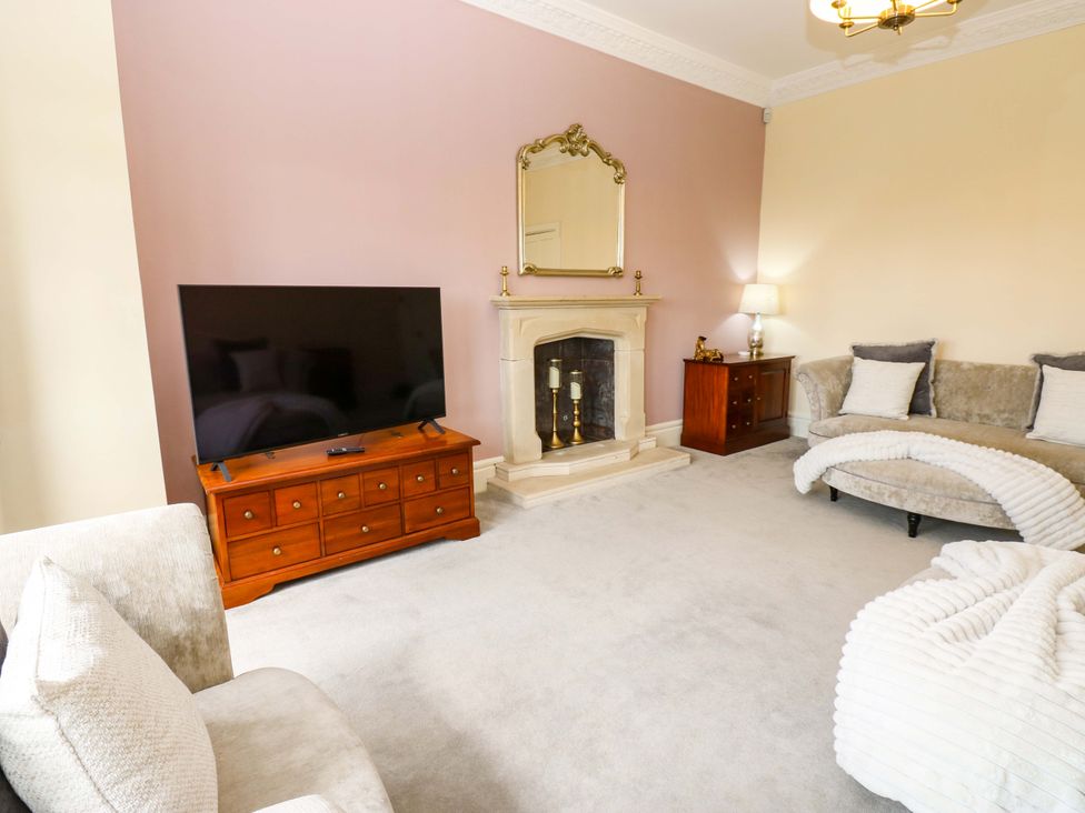 A living room with a television and fireplace at Flaxstead Grange in Newbottle