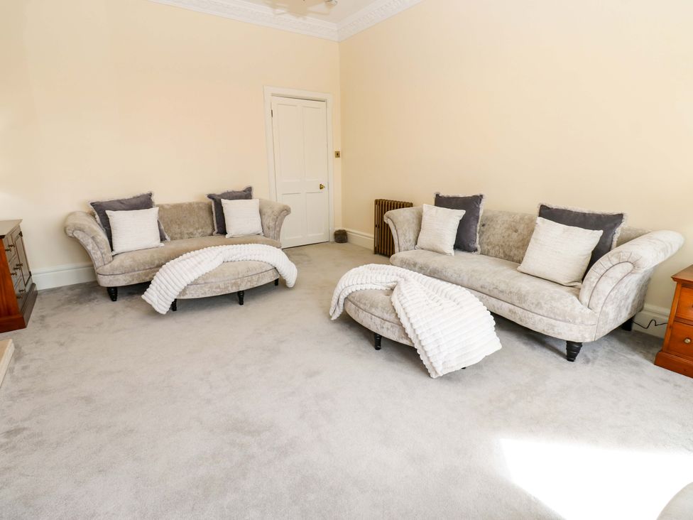 A living room with two sofas and an ottoman at Flaxstead Grange in Newbottle