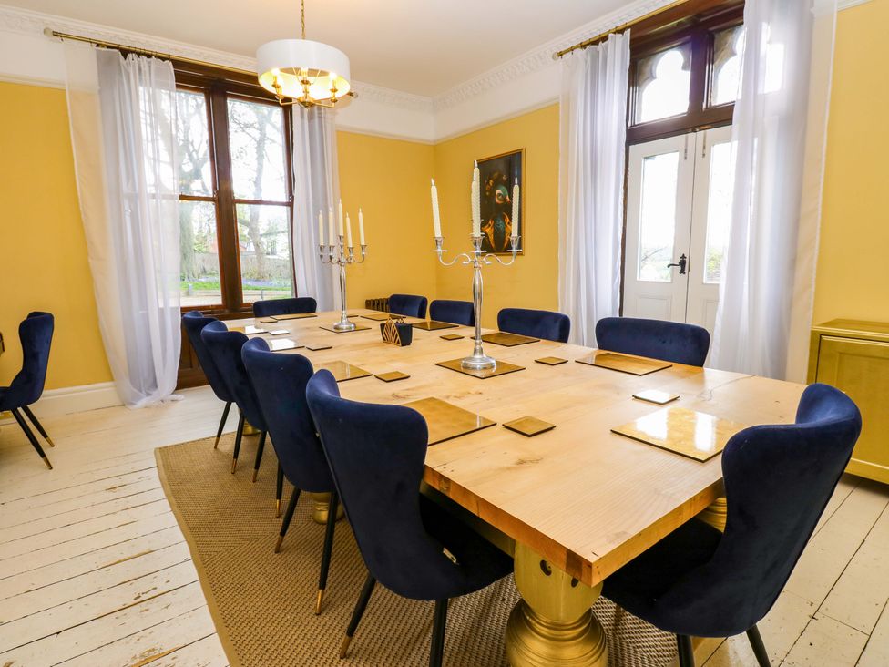 A dining room with a large table and blue chairs at Flaxstead Grange in Newbottle