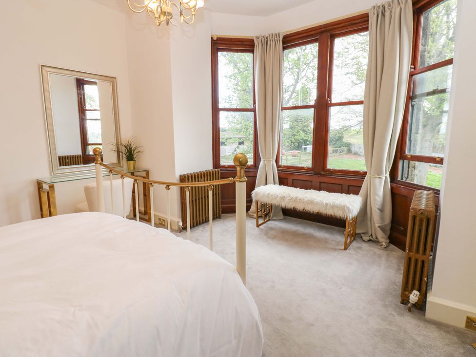 A bedroom with a bed and a bench at Flaxstead Grange in Newbottle