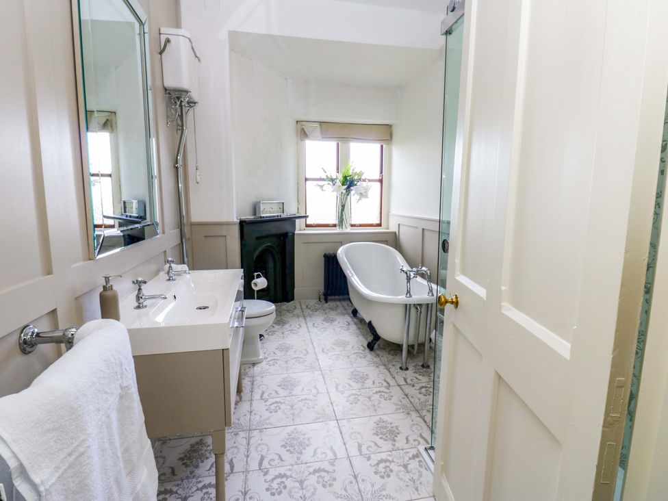 A bathroom with a bathtub, sink, and toilet at Flaxstead Grange in Newbottle
