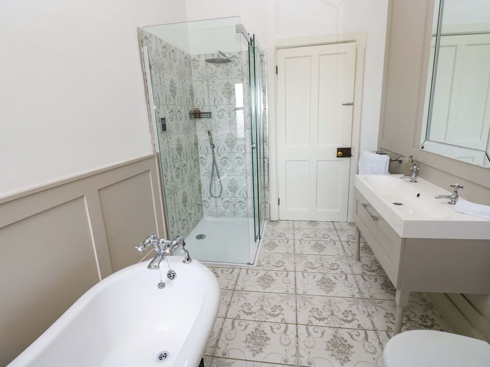 A bathroom with a bathtub, shower, sink, and toilet at Flaxstead Grange in Newbottle